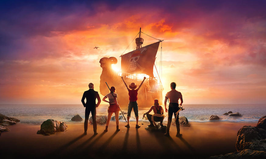 Netflix 真人版“海贼王”的宣传艺术。 五名船员背对着我们面对海岸线。 在中央，猴子 D. 路飞（Iñaki Godoy）胜利地举起双臂站立。 背景中一艘海盗船驶近海面。
